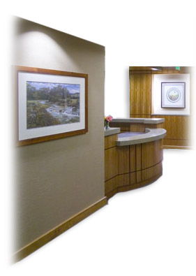 An office with a large desk and a few art pieces on the wall