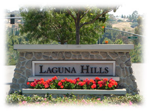 Laguna Hills sign with red flowers planted in front of the sign